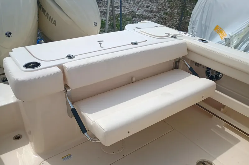 Slide: The Image of 2025 Grady-White Freedom 275 boat seating area with cup holders and Yamaha engines. - 9