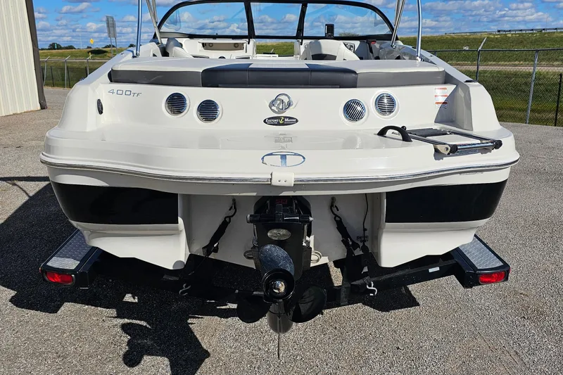 Slide: The Image of 2016 Tahoe 400 TF boat rear view, parked on a trailer, under a clear blue sky. - 3