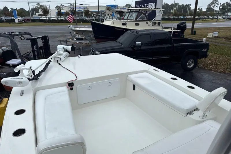 Slide: The Image of 2017 Bay Rider 2260 FS Skiff with white seating and trolling motor, parked near a road. - 3