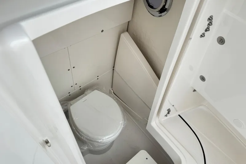 Slide: The Image of 2026 Robalo R250 Center Console boat interior with compact marine toilet. - 13