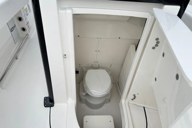 Slide: The Image of 2026 Robalo R250 Center Console boat interior with compact marine toilet. - 14