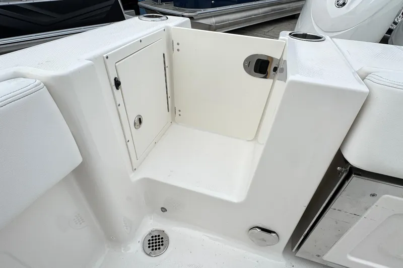 Slide: The Image of 2026 Robalo R250 Center Console boat storage compartment with white interior and drain. - 20