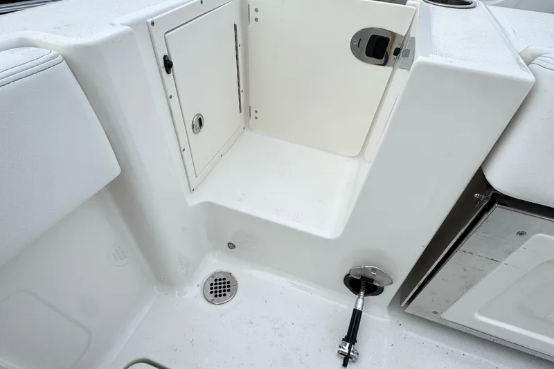 Slide: The Image of 2026 Robalo R250 Center Console boat interior with storage compartment and drain. - 23