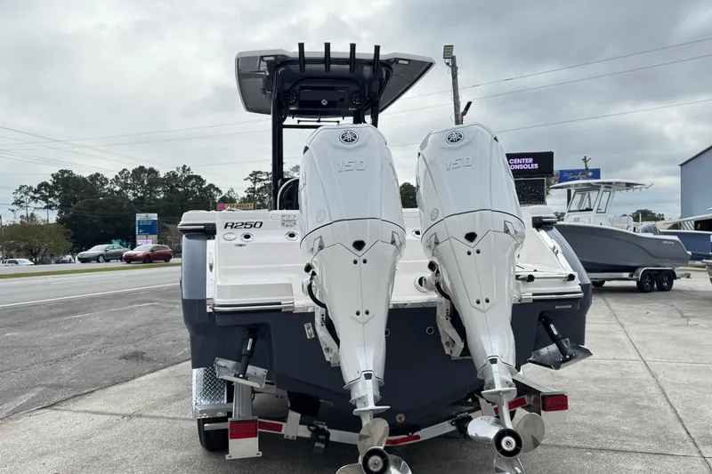 Slide: The Image of 2026 Robalo R250 Center Console boat with dual outboard engines, parked outdoors. - 34
