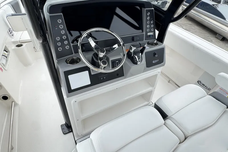 Slide: The Image of 2026 Robalo R250 Center Console boat helm with modern controls and steering wheel. - 6