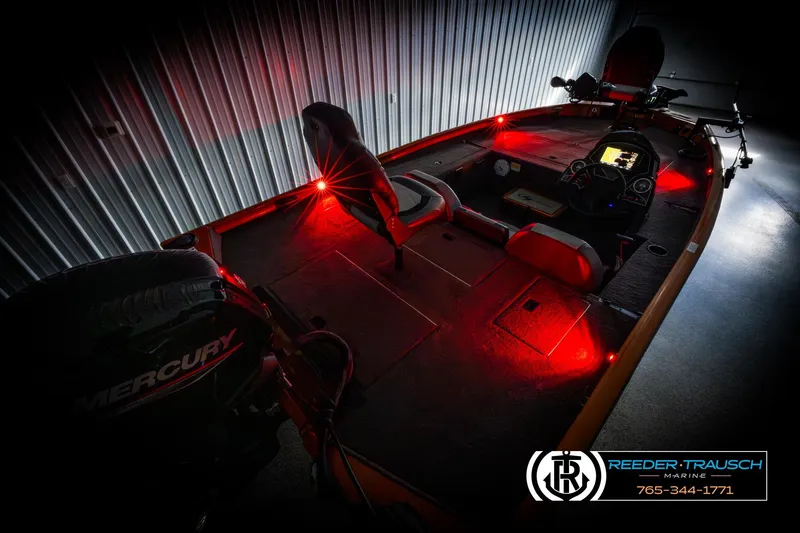 Slide: The Image of 2022 Lowe Stinger 178 boat interior with red LED lighting and Mercury engine. - 11