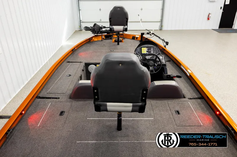 Slide: The Image of 2022 Lowe Stinger 178 boat interior with steering console and seating in a showroom. - 12