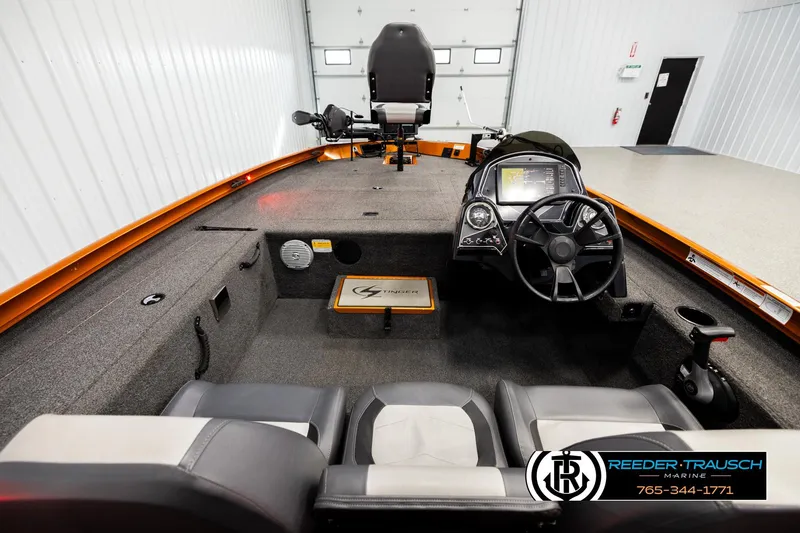 Slide: The Image of 2022 Lowe Stinger 178 boat interior with steering console and seating in a showroom. - 13