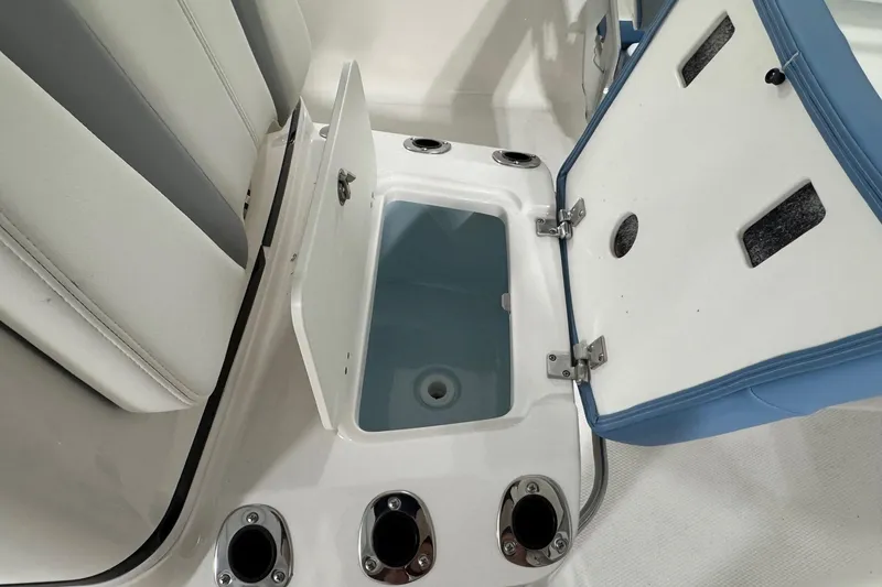 Slide: The Image of Open storage compartment on 2026 Robalo 206 Cayman boat, featuring rod holders and seating. - 18