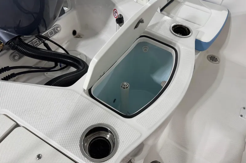 Slide: The Image of 2026 Robalo 206 Cayman boat interior with open storage compartment and cup holders. - 9