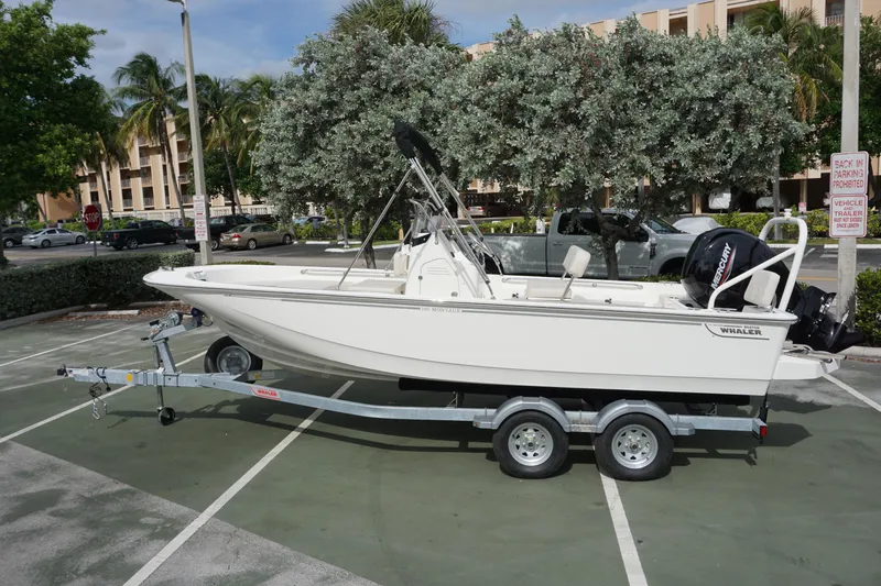 Slide: The Image of 2026 Boston Whaler 190 Montauk boat on trailer in parking lot. - 1