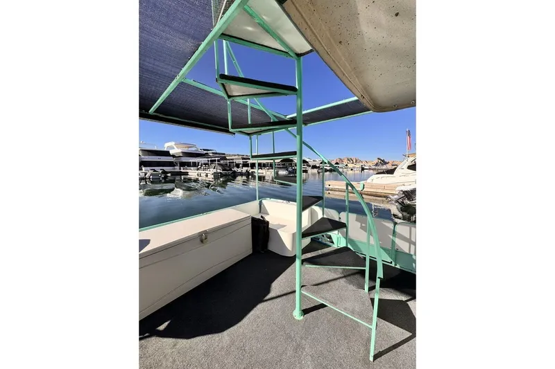 Slide: The Image of Spiral staircase on 1984 Boatel Hercules houseboat, docked at marina with clear blue sky. - 15