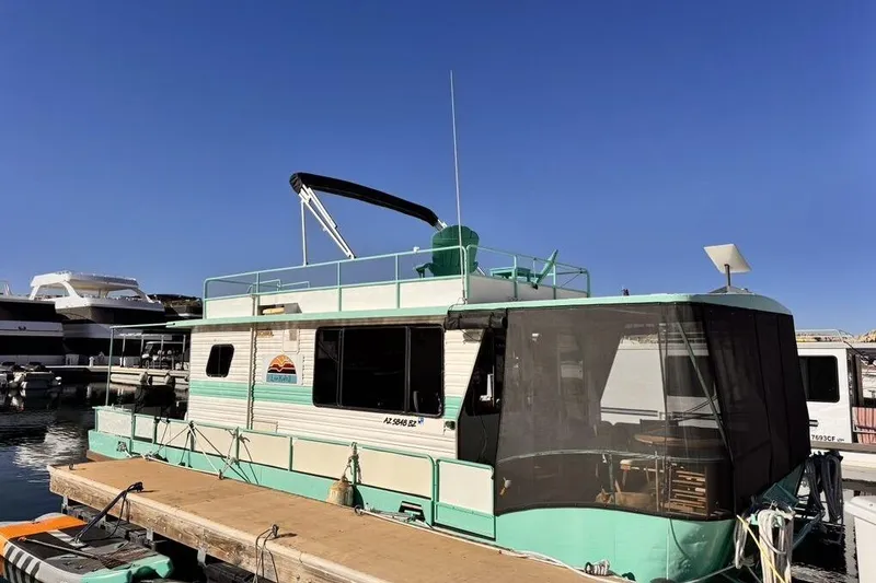 Slide: The Image of 1984 Boatel Hercules houseboat docked under clear blue sky. - 3