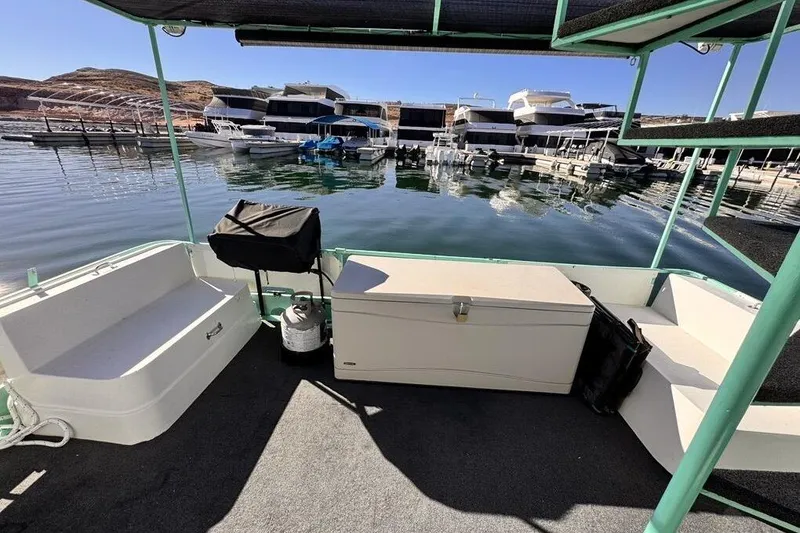 Slide: The Image of 1984 Boatel Hercules boat interior with seating and storage, docked at a marina. - 6
