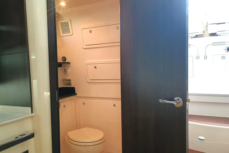 Slide: The Image of 2025 Grady-White Canyon 386 boat bathroom interior with modern fixtures and storage compartments. - 19