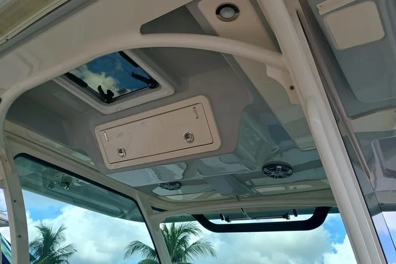 Slide: The Image of 2025 Grady-White Canyon 386 boat interior ceiling with hatch and speakers, under blue sky. - 27