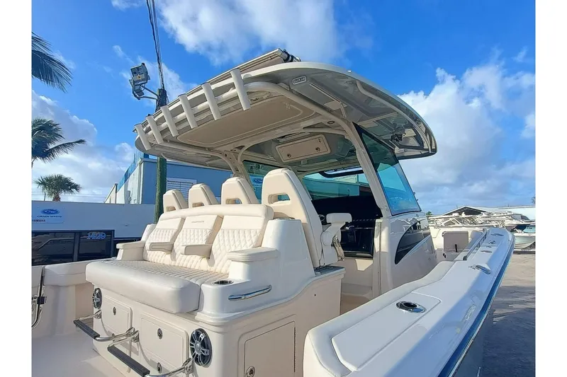 Slide: The Image of 2025 Grady-White Canyon 386 boat with luxurious seating and sleek design under a clear blue sky. - 32