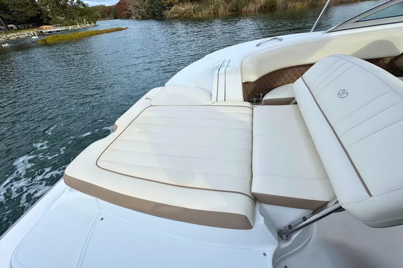 Slide: The Image of 2010 Cobalt 242 boat with beige seating on a calm lake. - 10