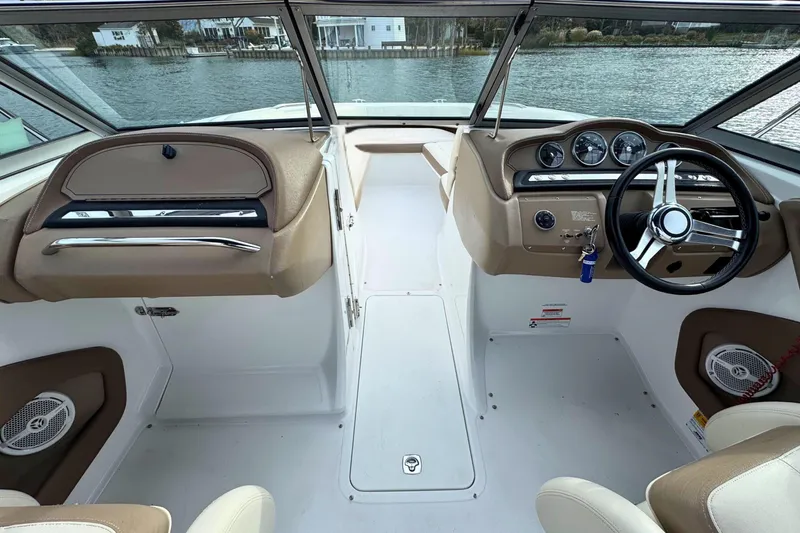 Slide: The Image of 2010 Cobalt 242 boat interior with steering wheel and dashboard, docked by the water. - 12