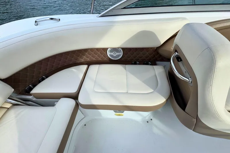 Slide: The Image of 2010 Cobalt 242 boat interior with beige and brown seating, near water. - 15