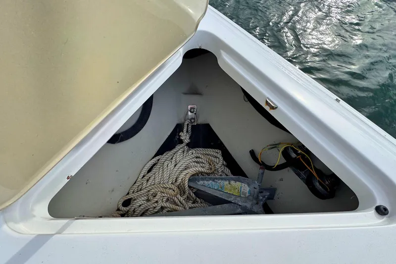 Slide: The Image of Open anchor compartment on 2010 Cobalt 242 boat with rope and anchor. - 25