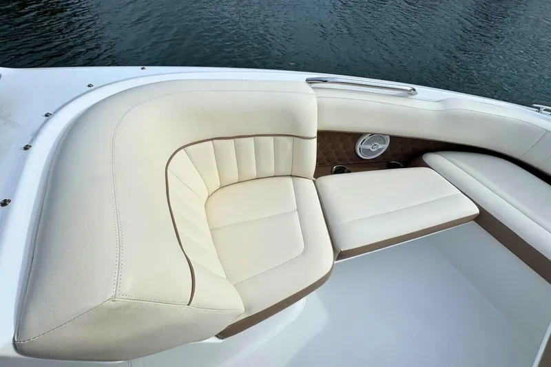 Slide: The Image of Luxurious seating on a 2010 Cobalt 242 boat, featuring cream upholstery and water backdrop. - 26