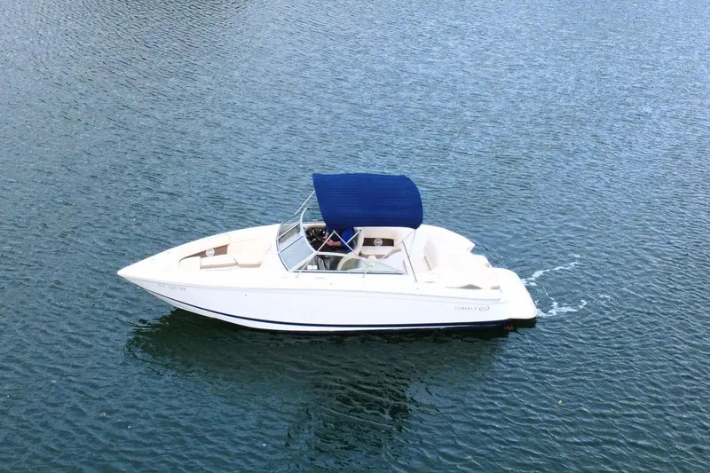 Slide: The Image of 2010 Cobalt 242 boat with blue canopy cruising on calm water. - 8