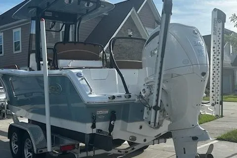 Slide: The Image of 2023 Sea Hunt Ultra 239 SE boat cruising on a serene lake. - 2