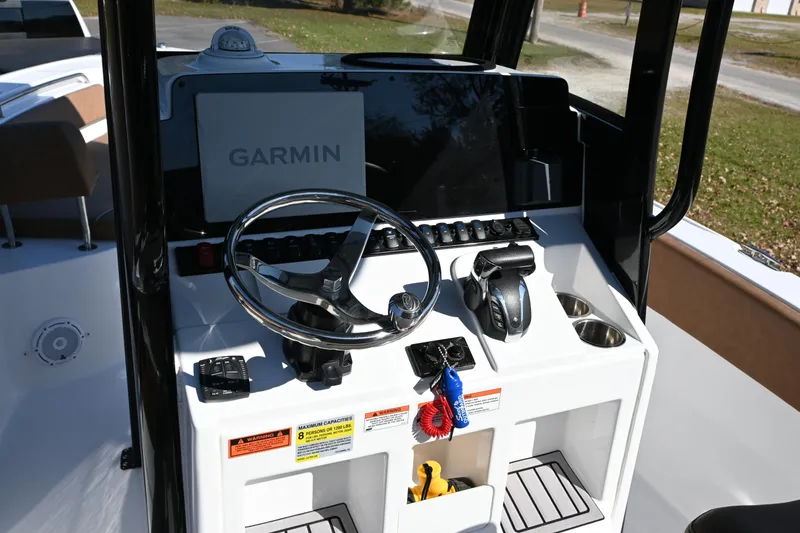 Slide: The Image of 2023 Sea Hunt Ultra 239 SE boat console with Garmin navigation system and steering wheel. - 25