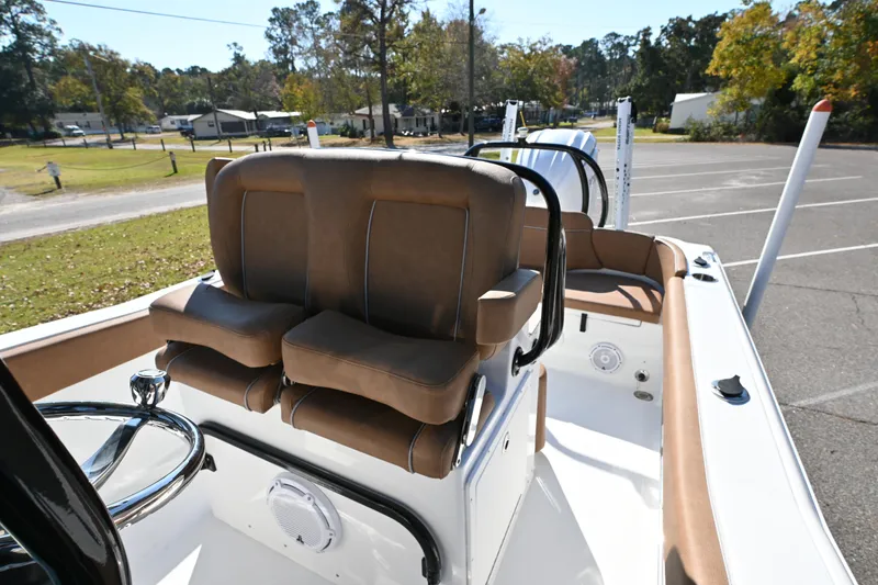 Slide: The Image of 2023 Sea Hunt Ultra 239 SE boat interior with brown seating and steering wheel. - 29