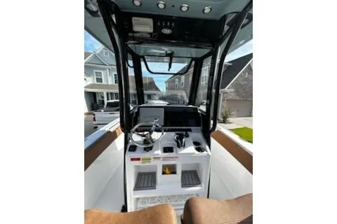 Slide: The Image of 2023 Sea Hunt Ultra 239 SE boat cruising on a lake with a scenic backdrop. - 7