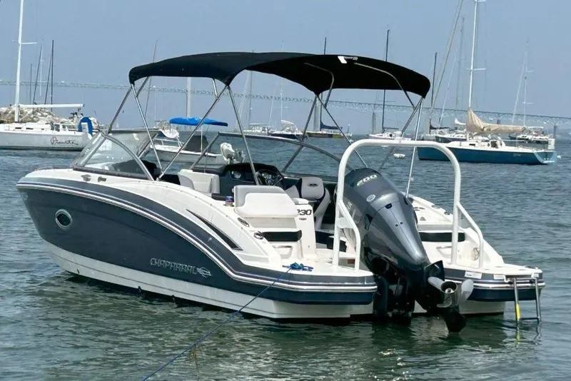 Slide: The Image of 2021 Chaparral 230 Suncoast boat with outboard motor, anchored in a marina. - 2
