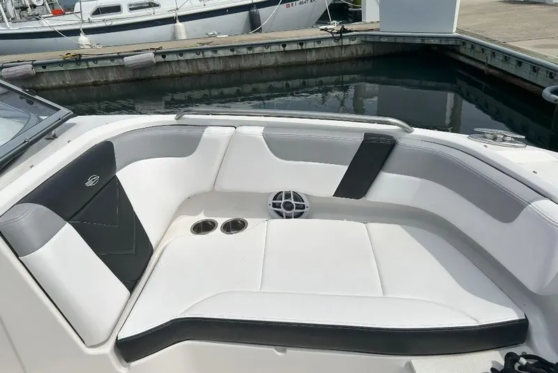 Slide: The Image of 2021 Chaparral 230 Suncoast boat interior with white and black seating at a marina. - 7
