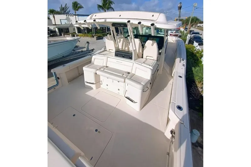 Slide: The Image of 2025 Grady-White Canyon 456 boat interior with seating and helm, docked outdoors. - 7