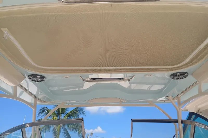 Slide: The Image of 2025 Grady-White Canyon 456 boat interior ceiling with speakers, tropical background. - 15