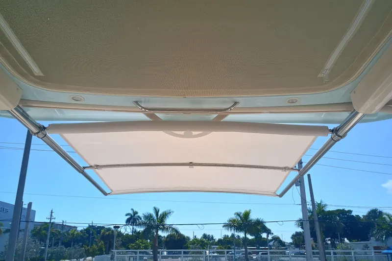 Slide: The Image of 2025 Grady-White Canyon 456 boat canopy with clear sky and palm trees. - 16