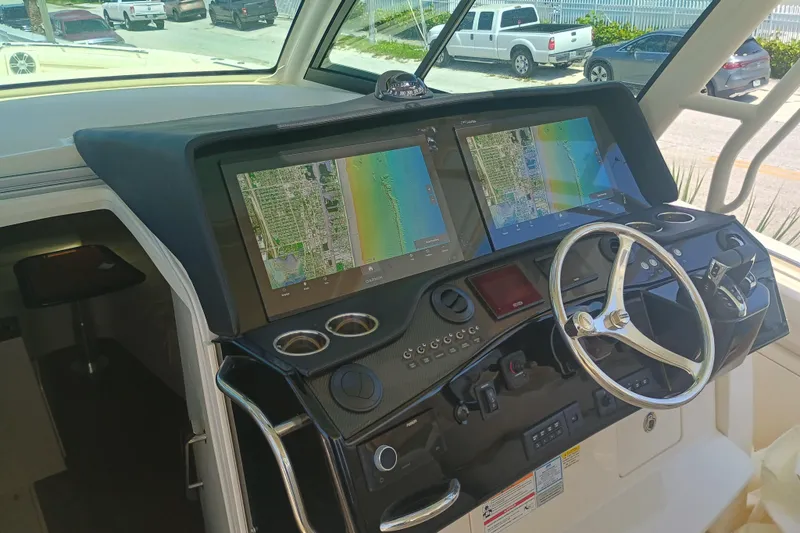 Slide: The Image of 2025 Grady-White Canyon 456 helm with dual navigation screens and steering wheel. - 29