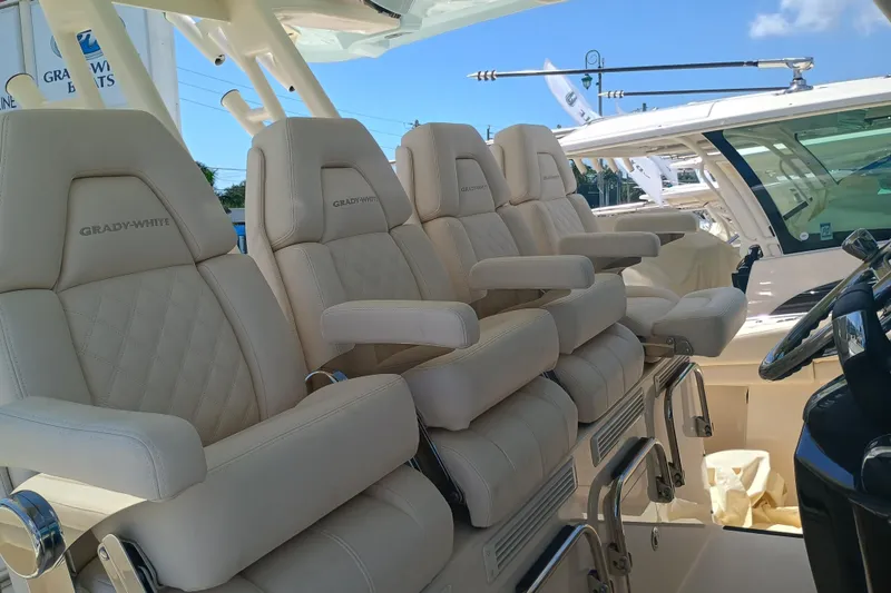 Slide: The Image of Luxurious seating on 2025 Grady-White Canyon 456 boat, featuring plush, cream-colored upholstery. - 30