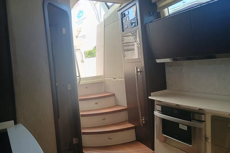 Slide: The Image of Interior of 2025 Grady-White Canyon 456 boat, featuring modern kitchen and wooden stairs. - 36