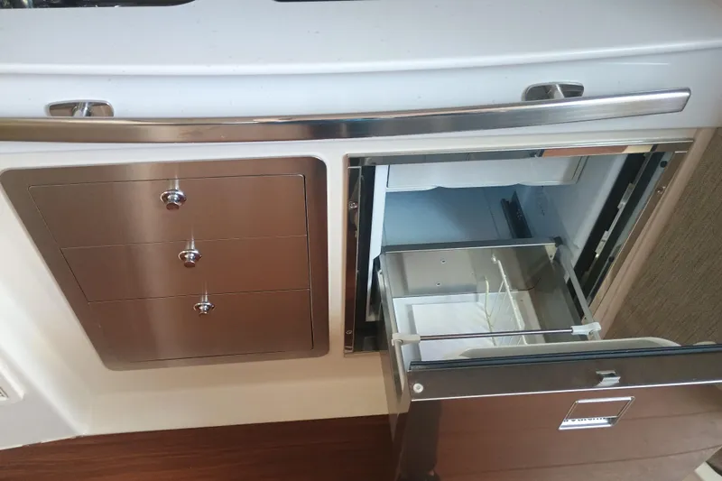 Slide: The Image of 2025 Grady-White Canyon 456 interior with stainless steel drawers and open fridge. - 37