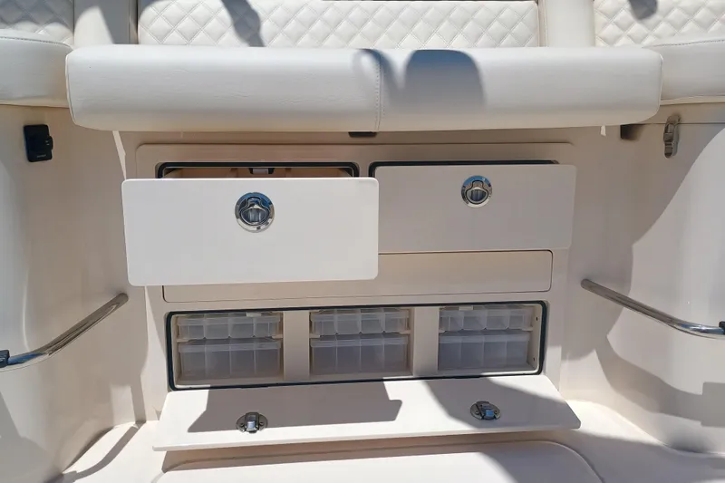 Slide: The Image of 2025 Grady-White Canyon 456 boat storage compartments with white cushioned seating. - 47