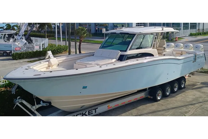 Slide: The Image of 2025 Grady-White Canyon 456 boat on trailer, parked outdoors, showcasing sleek design and multiple engines. - 48