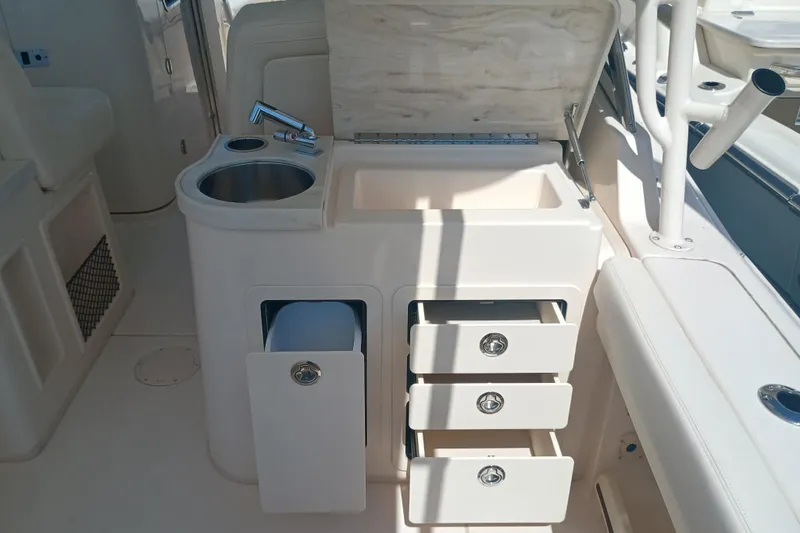 Slide: The Image of 2025 Grady-White Canyon 456 boat interior with sink, storage drawers, and countertop. - 5