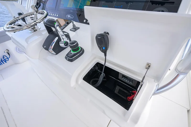 Slide: The Image of 2024 Valhalla Boatworks V-46 helm with controls, steering wheel, and communication equipment. - 16