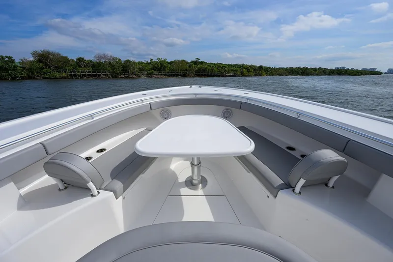 Slide: The Image of 2024 Valhalla Boatworks V-46 interior with seating and table on calm water. - 24