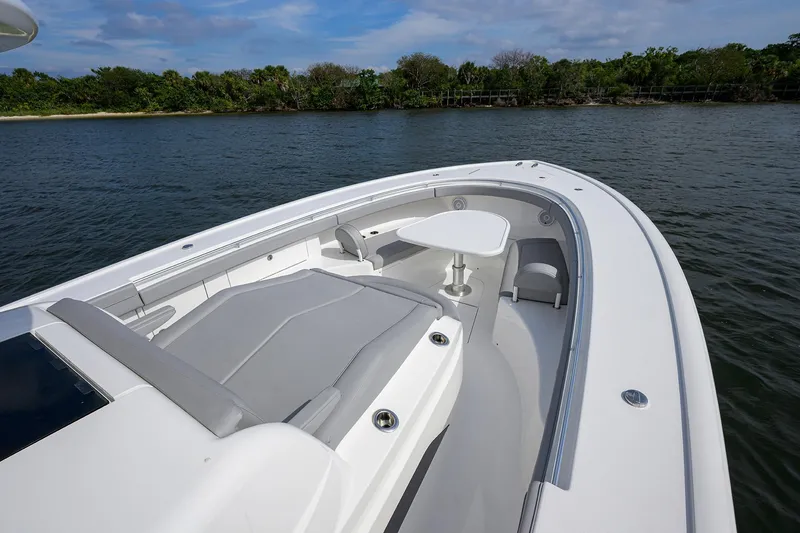 Slide: The Image of 2024 Valhalla Boatworks V-46, sleek deck design with seating and table, on calm water. - 25