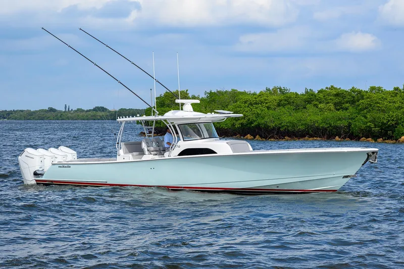 Slide: The Image of 2024 Valhalla Boatworks V-46 cruising on water with lush green shoreline. - 8