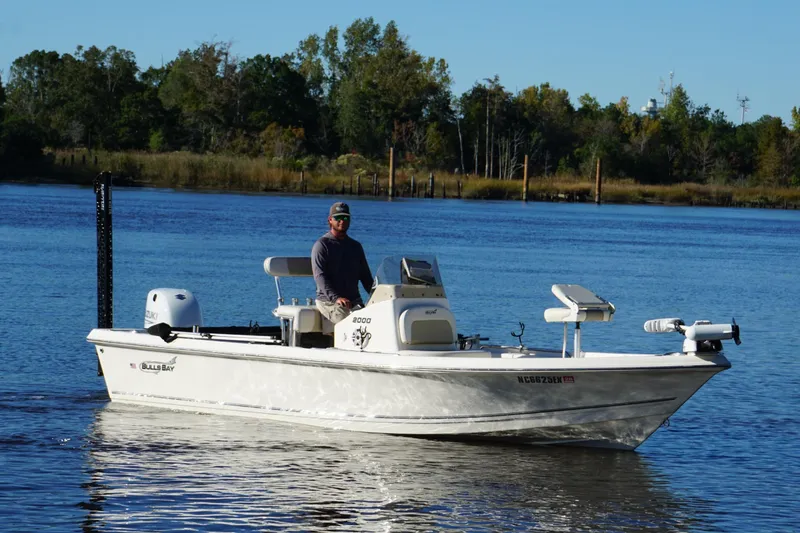 The Image of 2022 Bulls Bay 2000 boat on a calm lake with a person at the helm. - 0