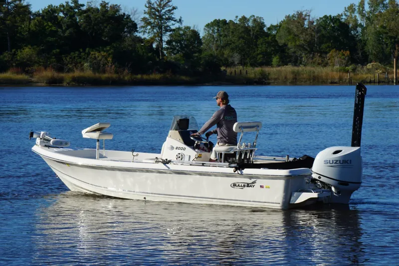 Slide: The Image of 2022 Bulls Bay 2000 boat on calm water with Suzuki outboard motor. - 2