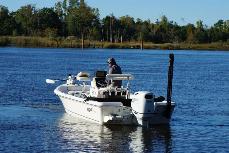 Slide: The Image of Bulls Bay 2000 boat on a serene lake, 2022 model, with lush greenery in the background. - 3